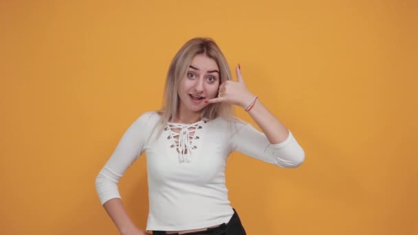 Teenager kavkazská žena dělá gesto telefonu a pochybuje — Stock video