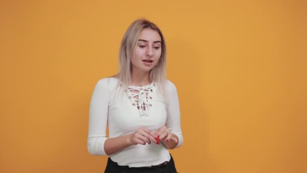 Молода кавказька приваблива жінка багато посміхається, прикриваючи рот — стокове відео