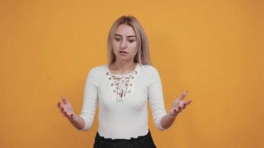 Beyaz tenli çekici kız omuzlarını kaldırırken önemsiz bir jest yapıyor.