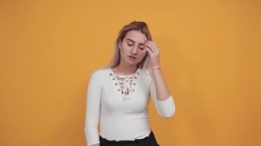 Rahat genç bir kadın günlük giysiler içinde gözleri açık, elleri başının arkasında.