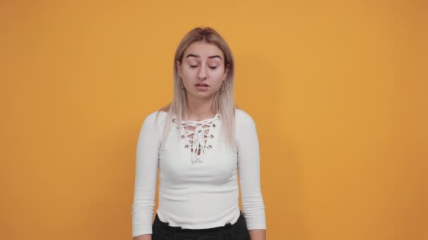 Hezká mladá běloška ukazuje prsty na hlavu, jako by se chtěla zastřelit — Stock video