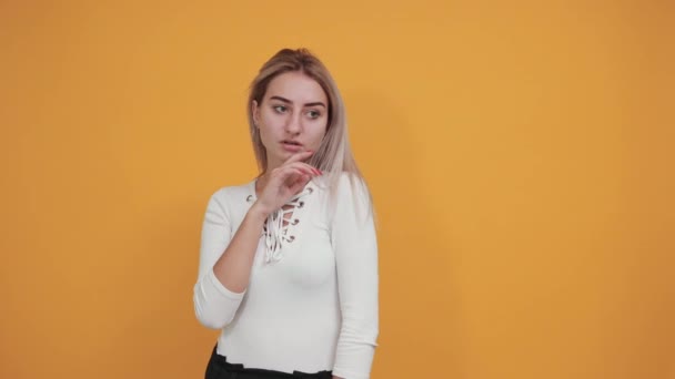 Porträtt av söt leende ung kvinna i vit skjorta hand stötta upp på munnen — Stockvideo