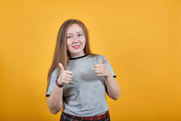 Atractiva mujer caucásica mostrando buen gesto, manteniendo el pulgar hacia arriba, sonriendo — Foto de Stock