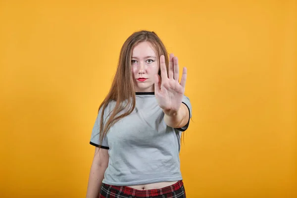 Portret van een serieuze jonge vrouw in casual kleding met stop gebaar met palm — Stockfoto