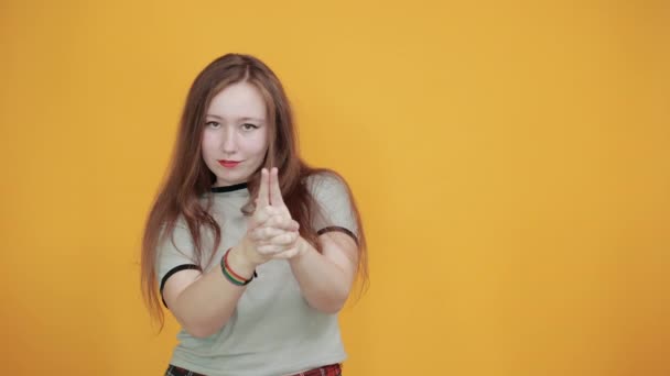 Porträt einer Frau im grauen Hemd, die wartet und den Finger wie eine Waffe in die Höhe hält — Stockvideo