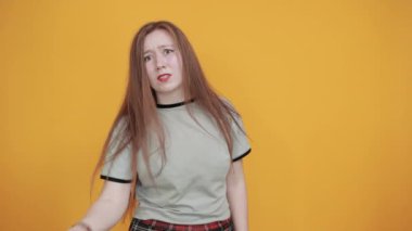 Rahat genç bir kadın, gündelik giysiler içinde başını yana kaldırıyor, elleri alnında.