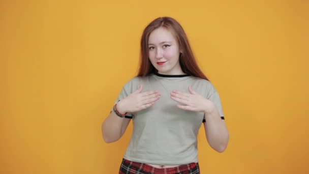 Молодая привлекательная белая женщина в красивой одежде показывает форму сердца с руками — стоковое видео