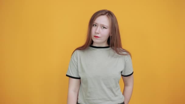 Krásná mladá dáma na sobě hezké tričko zůstat ukazuje prstem pryč — Stock video