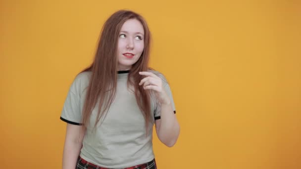 O femeie atractivă strigă și anunță ceva, ținându-se de mână lângă obraz — Videoclip de stoc