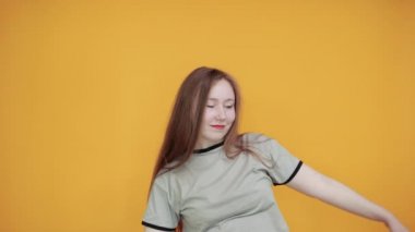 Joyful young woman in casual clothes rising hands with closed eyes
