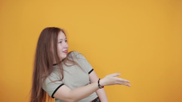 Attractive woman over isolated orange wall speaking, keeping hand near mouth — Stock Video