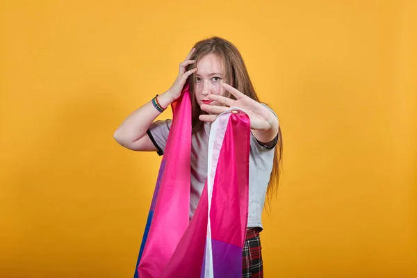 Retrato de una joven mostrando un gesto de stop manteniendo la bandera bisexual —  Fotos de Stock