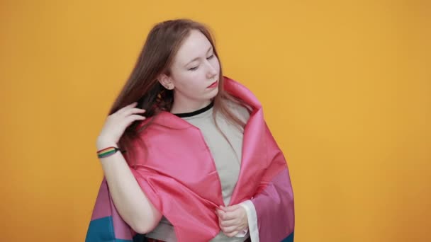 Nő tartja a kezét a fejen, játszik a hajjal, fedett biszexuális zászló — Stock videók
