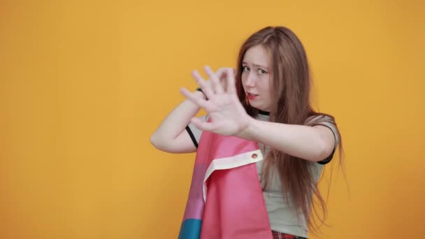 Mladá žena ukazuje stop gesto udržet bisexuální vlajku s dlaní — Stock video