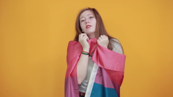 Mujer joven con pulgares en las mejillas, bandera bisexual cubierta . — Vídeo de stock