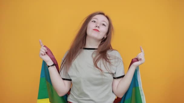 Привлекательная женщина улыбается, держит пальцы на щеках, покрывает ЛГБТ-флаг — стоковое видео