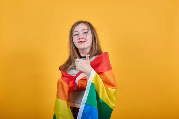 Pretty young girl keeping fist up, covering LGBT flag — Stock Photo, Image