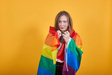 Güzel beyaz kadın yumruklarını göğsüne dayayıp Lgbt bayrağını kapatıyor.