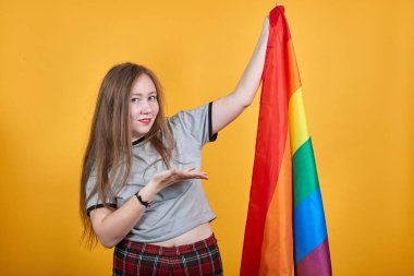 Lgbt bayrağında uzanmış elini gösteren çekici bir kadın.