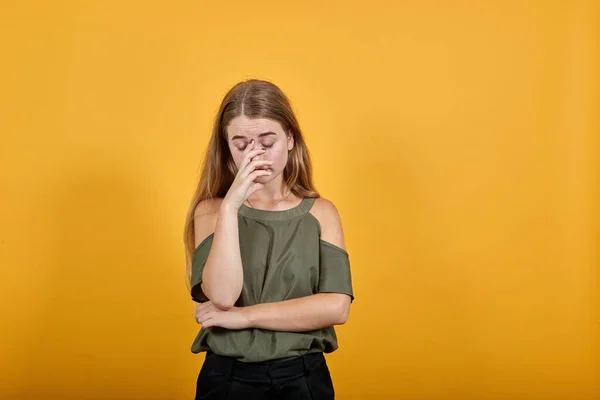 Портрет смущенной молодой женщины с закрытыми глазами и закрывающим нос рукой — стоковое фото