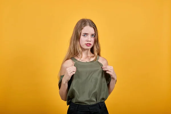 Ritratto di piacevole giovane donna in camicia casual che tiene le dita della camicia, cuore — Foto Stock