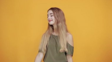 Gülümseyen, sıradan giysiler içinde, el ele tutuşan genç bir kadın.