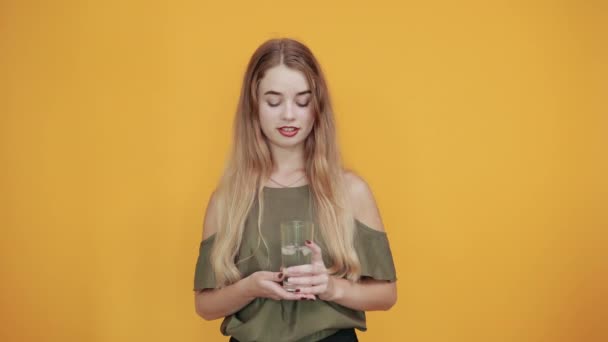 Ung blond kvinna flicka i casual kläder hålla glas vatten — Stockvideo