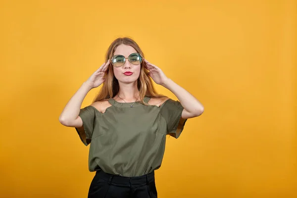 Opgewonden jong meisje in pastel kleding houden zonnebril fkeeping handen op haar — Stockfoto