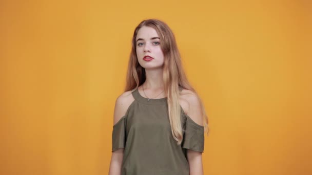 Mooie vrouw draagt casual shirt houdt handen op de wangen, kijkt zo bang — Stockvideo