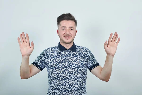 Shocked cheerful young man in shirt, looking at camera, spreading hands — Stock Photo, Image