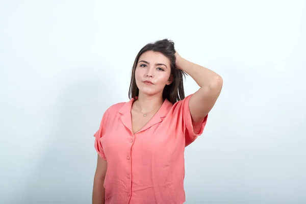 Jovem mulher na parede branca com uma expressão de frustração, não compreendendo — Fotografia de Stock
