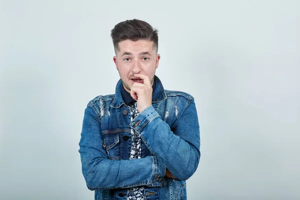 Hombre joven en chaqueta de mezclilla de moda que cubre la boca con la mano, mirando directamente — Foto de Stock