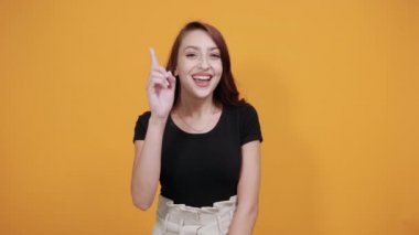 Siyah gömlekli güzel bir kadın, elini belinde tutuyor, doğrudan işaret ediyor.