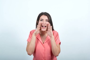 Genç kadın bağırıyor ve bir şey ilan beyaz duvar yüzünden