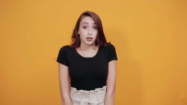 Atraktivní mladá žena v černé košili, foukající rty, držící palec dolů — Stock video