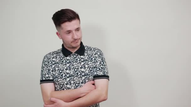 Cheerful young man in shirt spreading hand isolated on gray wall — Stock Video