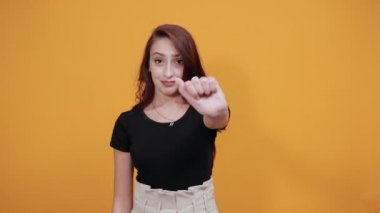 Siyah tişörtlü çekici bir kadın altı parmağını gösteriyor, gülümsüyor, gülüyor.