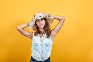 Çekici genç bir kadın ellerini başının üstünde tutuyor, komik görünüyor.