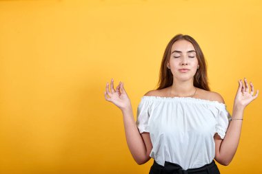 Yoga yapan, rahatlatan, meditasyon yapan çekici genç bir kadın.