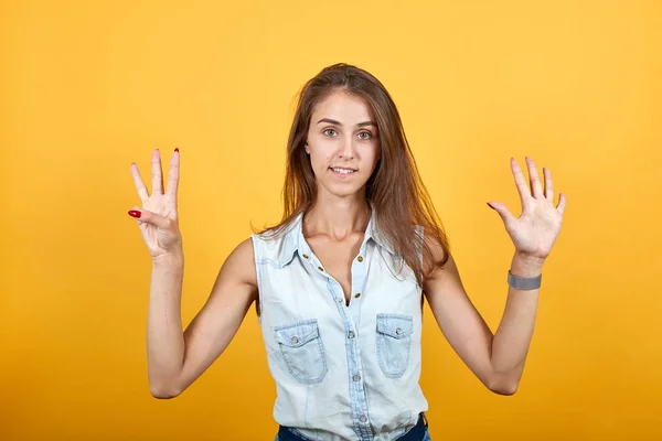 Loco caucásico joven mujer en azul denim camisa empujando nueve dedos —  Fotos de Stock