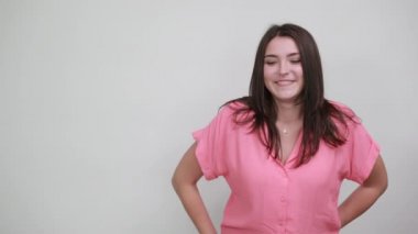 Pembe tişörtlü çekici genç bir kadın. Gözlerini elleriyle kapatıyor, üzgün görünüyor.