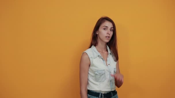 Скучная кавказская молодая женщина делает победный жест, держа руку на щеке — стоковое видео