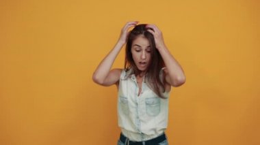 Kafkasyalı genç bir kadın ellerini başının üstünde tutuyor, korkmuş, şok olmuş görünüyor.