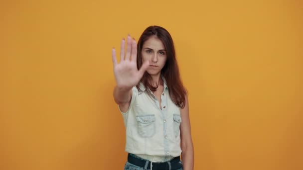 Charmante vrouw in blauw denim shirt bedekt ogen met de hand, doen stop gebaar — Stockvideo