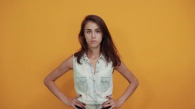 Hayal kırıklığına uğramış kadın sert görünüyor, ellerini çapraz tutuyor, belinden tutuyor.