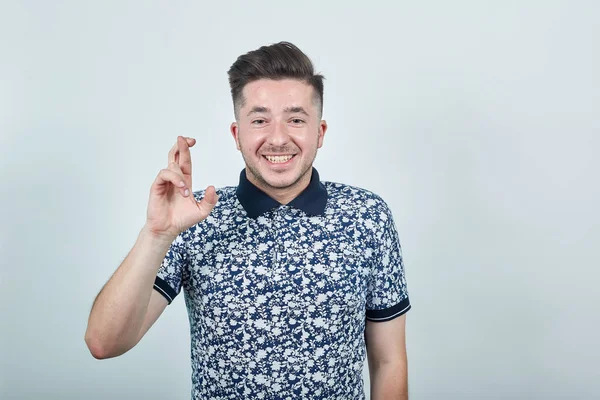 Handsome guy with fingers crossed as he is wishing best of luck. — Stock Photo, Image