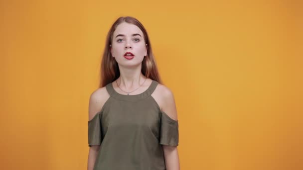 Mujer joven con expresión facial sorpresa, cubriendo la boca con las manos — Vídeo de stock