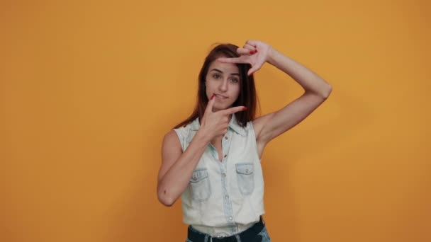 Cheerful caucasian young woman doing frame with fingers, looking happy — Stock Video