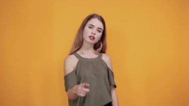 Moda kıyafetleri içinde güzel bir kız yumruğunu havada tutuyor, mutlu görünüyor.