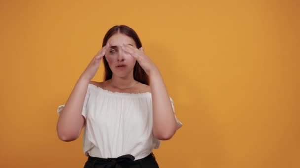 Потрясенная молодая женщина, держащая руки на голове, открыла рот — стоковое видео